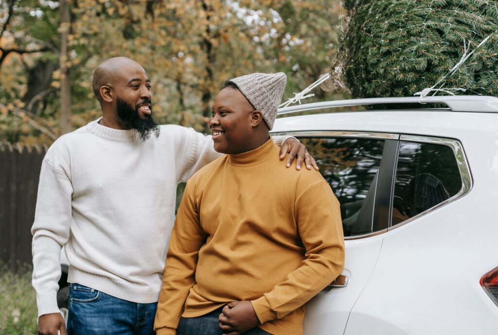 Father and son hugging beside their car